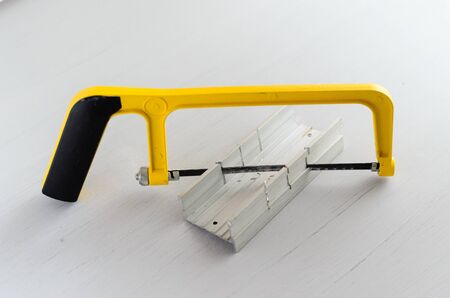yellow hand saw and aluminium miter box for hobby in home workshop.の写真素材