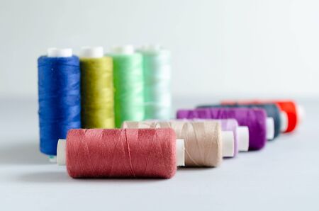Multi-colored spools of sewing threads close-up. Craft and hobby concept