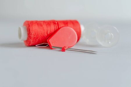 Red accessories for sewing on white background. Needlework and craft concept