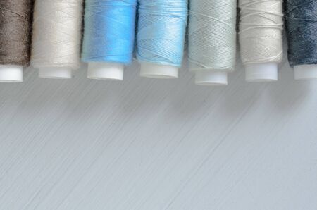 assorted of blue-gray thread spools on table, needlework and tailoring concept