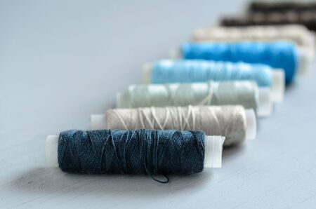 assorted of blue-gray thread spools on table, needlework and tailoring conceptの写真素材
