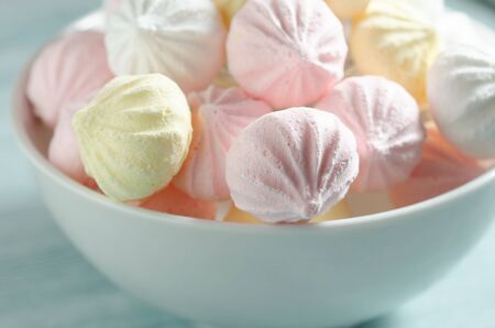 Meringues in a white bowl. Colorful delicious dessert