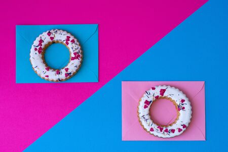 Creative layout made of glazed ring shape rolls, bagels with colorful hearts. Flat lay. Nature concept. Conceptual greeting card. Colorful spring background, space for text. Trendy Decorative Design.の写真素材