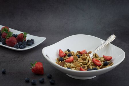 Pancake cereal. Trendy food, mini cereal pancakes in bowl on the table, grey cement background....