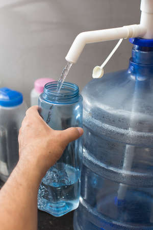 man filling water into bottleの写真素材