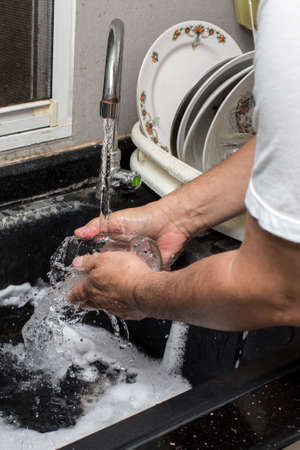 man washing glass in Sink