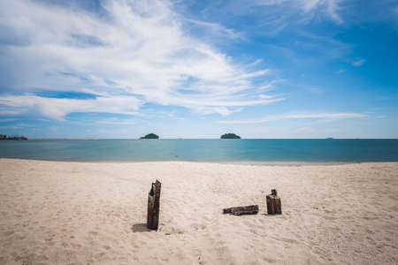Wood remains on a  sand beach in front of the sea.  Long exposureの写真素材