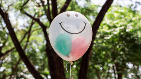 Transparent  balloon with smile face on green bokehの写真素材