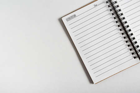 blank notebook with pen and pencil on white table