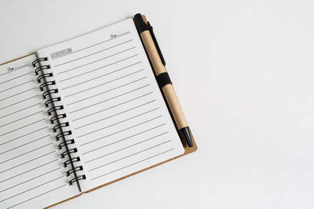blank notebook with pen and pencil on white tableの写真素材