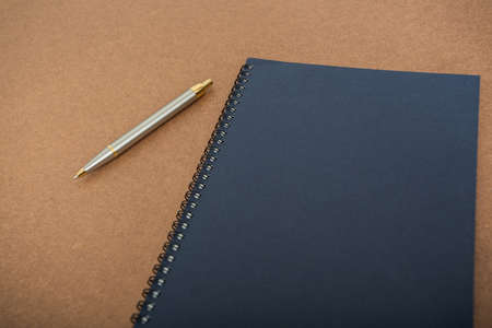 blank notebook with pen on wooden tableの写真素材