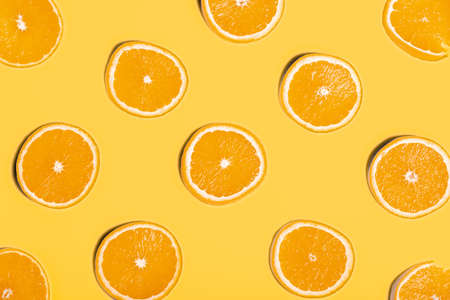 Slices of orange on yellow background
