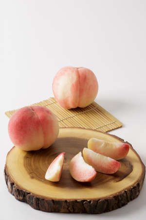 honey peach in wooden bowl on white backgroundの写真素材