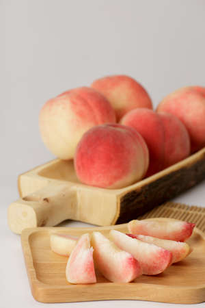 honey peach in wooden bowl on white backgroundの写真素材