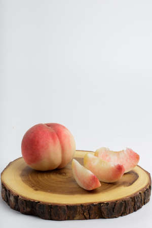 honey peach in wooden bowl on white backgroundの写真素材