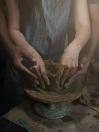 Romantic couple helping molding pottery, ceramic making on the machine. Handmade earthenware, Love concept.の写真素材