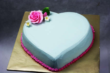 Plain and Cute heart shape cake light blue color with fondant flowerの写真素材