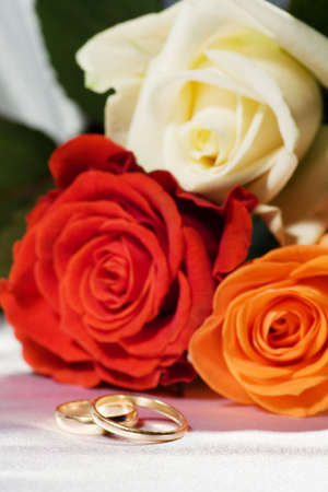 On a photo a roses and wedding ringsの写真素材