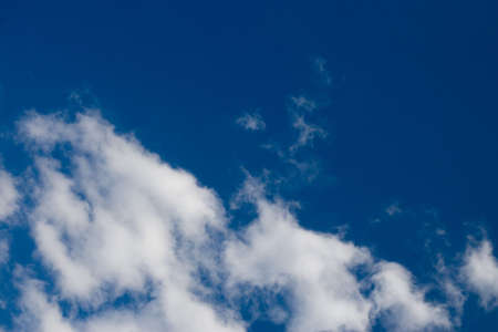 Some puffy cumulus clouds against a pretty blue sky.の写真素材