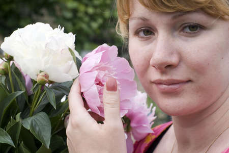 Beautiful young woman holding pink peonyの写真素材