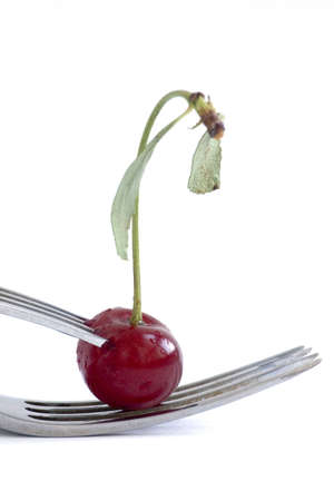 wet cherry with two fork over white backgroundの写真素材