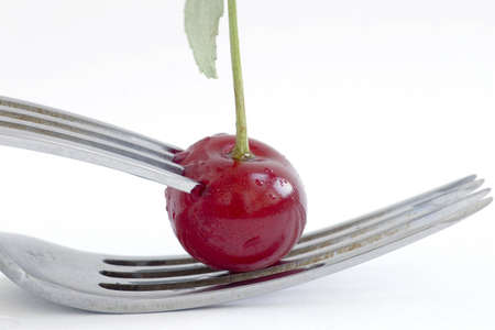 wet cherry with two fork over white backgroundの写真素材
