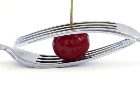 wet cherry with two fork over white backgroundの写真素材