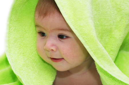 baby looking out from under blanketの写真素材