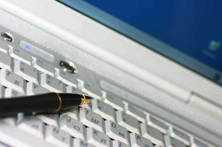 Business tools. Pen on the laptop.の写真素材