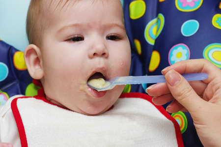 Mother feeding baby food to babyの写真素材