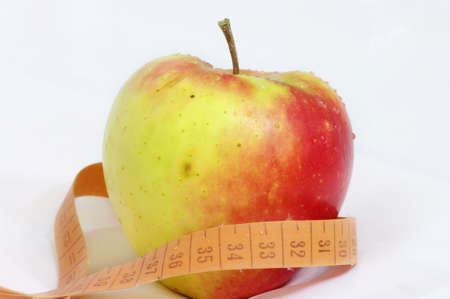 apple and measuring tape isolated on white backgroundの写真素材