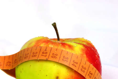 apple and measuring tape isolated on white backgroundの写真素材