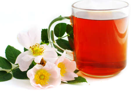 Herbal tea in cup of glass with dog-rose flowers on a white background.の写真素材