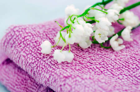 Spa setting of  towels, soap and lilies of the valley の写真素材