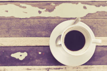top view of coffee cup on grunge wooden table in vintage style