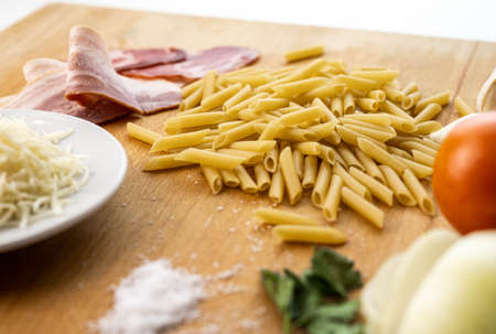 Variety of ingredients for cooking macaroni with sauceの写真素材