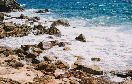 Image of a shore with rocks and sand on a Mediterranean beach