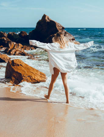 Young woman in a white shirt on the seashore. back viewの写真素材