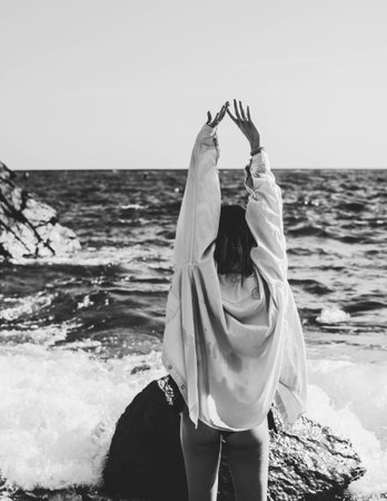 Girl in a white shirt on the background of the sea. Black and white photo.の写真素材