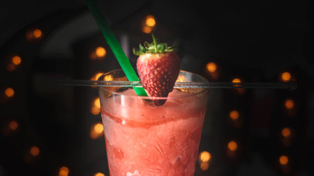 Strawberry smoothie in a glass with a straw on a dark backgroundの写真素材