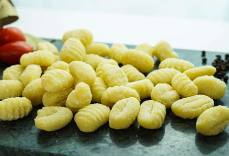 Kitchen table with fresh gnocchi ready to boilの写真素材