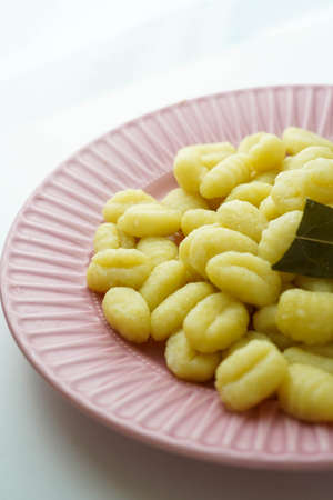 Plate of fresh gnocchi with olive oil and bay leafの写真素材