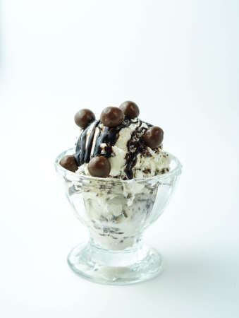 Scoops of ice cream with chocolate balls and syrupの写真素材
