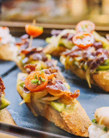 Different assorted canapes of bread with crab, ham and vegetables