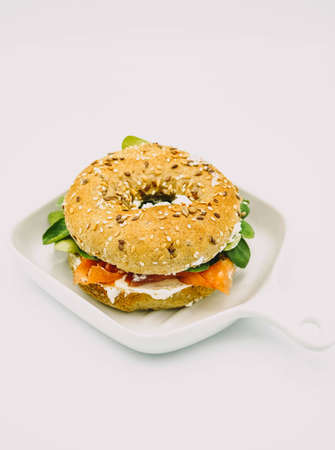 Bagel stuffed with smoked salmon, fresh cheese and arugulaの写真素材