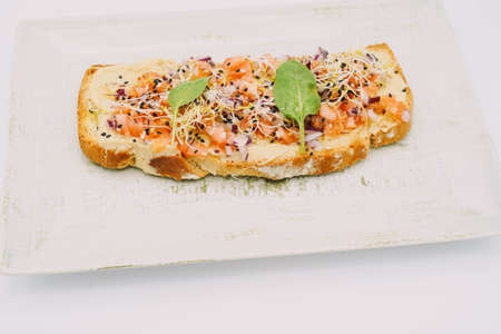 Tomato toast, onion, basil and spices.