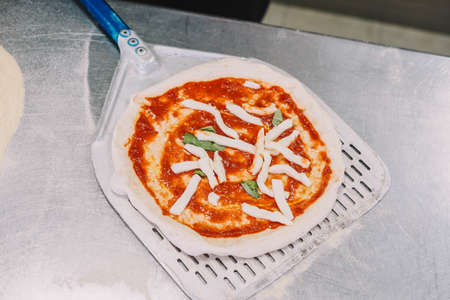 Preparation of a homemade Italian style pizza by a specialistの写真素材
