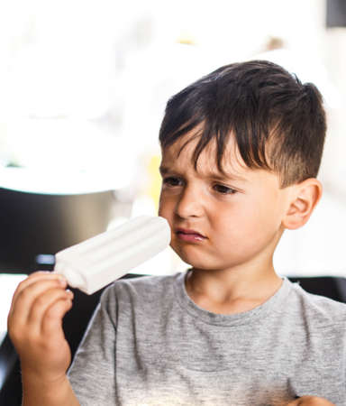 Caucasian boy enjoying a coconut lollyの写真素材