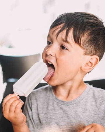 Caucasian boy enjoying a coconut lolly