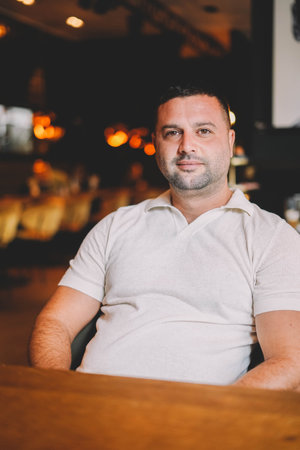 Middle aged man sitting in a bar having breakfastの写真素材